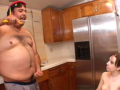Chubby guy eating while fucking a sexy brunette in his kitchen