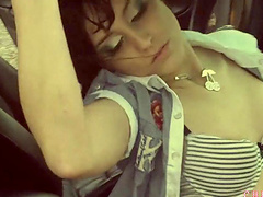 Lecherous lesbian pornstar fingering her pussy as she fondles her tits in a car