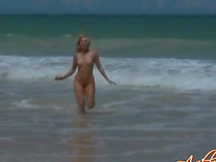 Dashing babe with natural tits posing nude on the beach