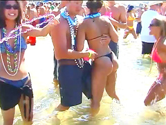 Delightful models in bikinis pose seductively for shots at a beach party