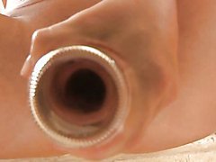 Melissa is pushing an empty bottle into her pussy and ass