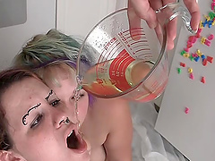 Chubby lesbian cowgirl with a shaved pussy drinking piss in the kitchen