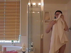 Randy babe with long brunette hair takes a shower in the bathroom