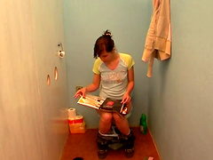 Amy sitting on a toilet when she sees a rod coming out of a glory-hole