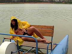 Out on a paddle boat she gets naked and plays with her pussy