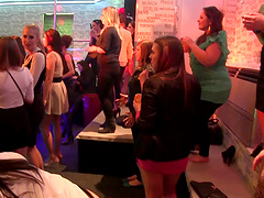 Wild girls in sexy clubbing clothes watch male strippers dance