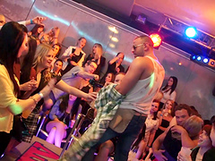 Wild girls in sexy clubbing clothes watch male strippers dance