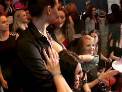 Wild girls in sexy clubbing clothes watch male strippers dance