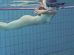 Petite redhead chick in pink bikini getting naked in the pool