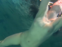 Alluring European teen with long hair swimming underwater