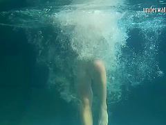 European brunette showcasing her shaved pussy in the pool