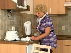 Slim teen and mature woman have sex in a kitchen