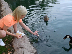 Outdoors video of solo blondie Kiara feeding the ducks in the pond