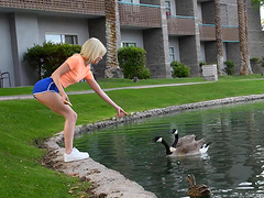 Outdoors video of solo blondie Kiara feeding the ducks in the pond