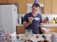 Good looking dude enjoys while cooking dinner in the kitchen
