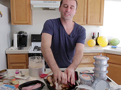 Good looking dude enjoys while cooking dinner in the kitchen