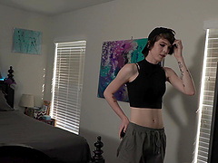 A young cute girl in a black dress, smiling, showing her breasts.