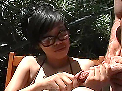 Gorgeous Asian babe in a bikini gets cum on her tits after milking a cock outdoors