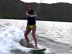 Wakeboarding on the lake is fun for the cute brunette