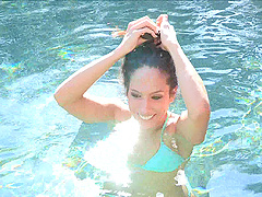 Bikini clad brunette jumps in the pool for an erotic outdoors shoot